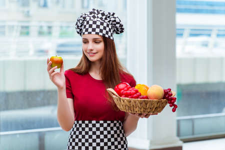 Young cook with fruits in the kitchenの写真素材