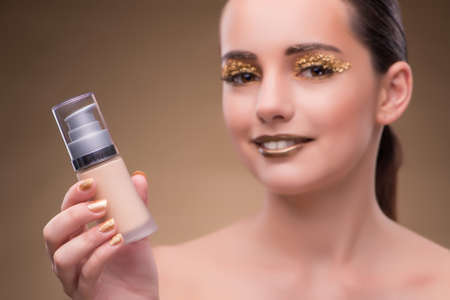 Woman with bottle of skincare cream