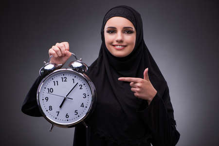 Muslim woman in black dress against dark backgroundの写真素材