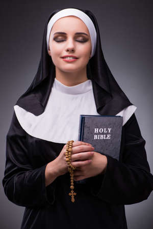 Religious nun in religion concept against dark backgroundの写真素材