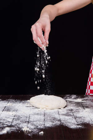 Cook preparing dough for baking in the kitchen