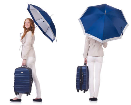 Young woman travelling with suitcase and umbrella isolated on whiteの写真素材