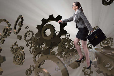 Woman businessman climbing cogwheelsの写真素材