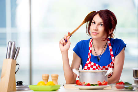 Female cook preparing soup in brightly lit kitchen