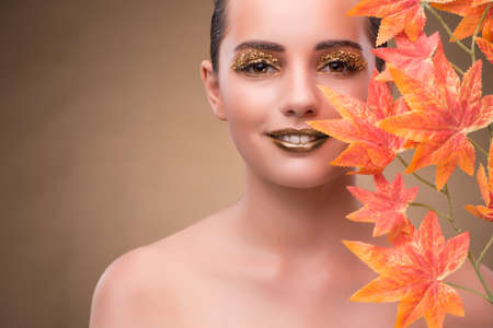 Young woman with dry autumn leavesの写真素材