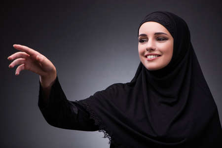 Muslim woman in black dress against dark backgroundの写真素材