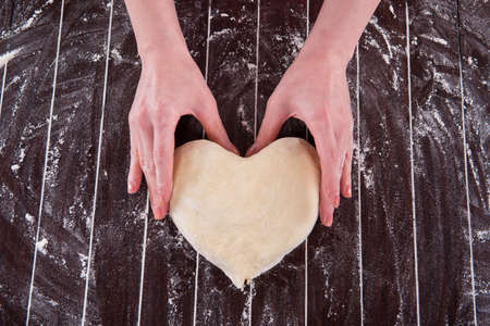 Cook preparing dough for baking in the kitchenの写真素材