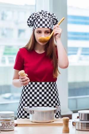 Young housewife preparing soup in kitchenの写真素材