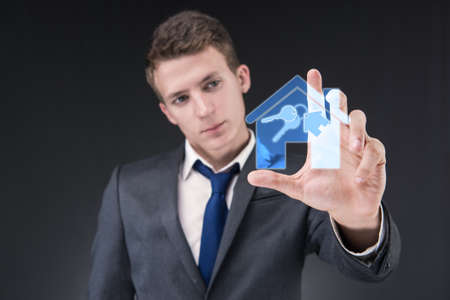 Young handsome businessman in mortgage conceptの写真素材