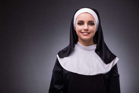 Religious nun in religion concept against dark backgroundの写真素材