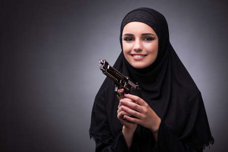 Muslim woman in black dress against dark backgroundの写真素材