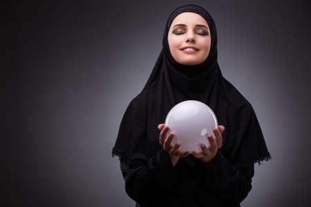 Muslim woman in black dress against dark backgroundの写真素材
