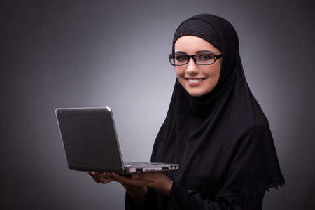 Muslim woman in black dress against dark backgroundの写真素材