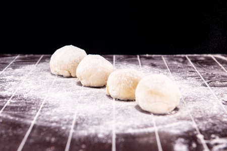 Cook preparing dough for baking in the kitchenの写真素材