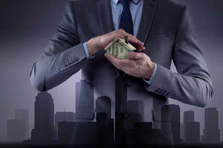 Young handsome businessman in mortgage conceptの写真素材