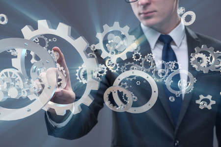Businessman with cogwheels gear in teamwork conceptの写真素材