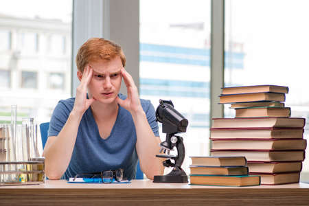 Young student tired and exhausted preparing for chemistry examの写真素材