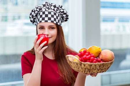 Young cook with fruits in the kitchenの写真素材