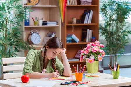 Young girl drawing pictures at home