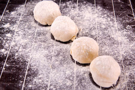 Cook preparing dough for baking in the kitchenの写真素材