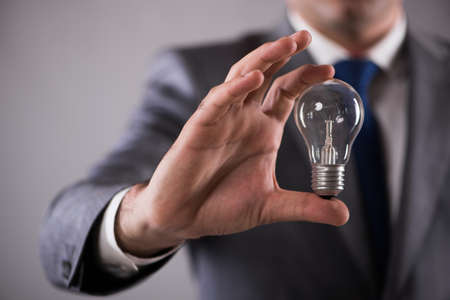 Businessman holding light bulb in creativity concept