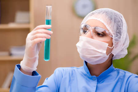 Lab chemist working with microscope and tubes