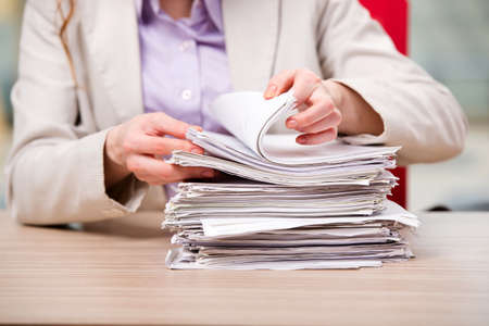 Businesswoman working with stack of papers