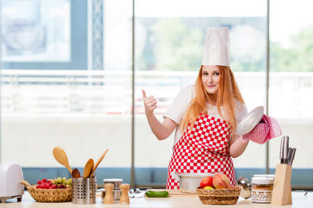 Redhead cook working in the kitchenの写真素材