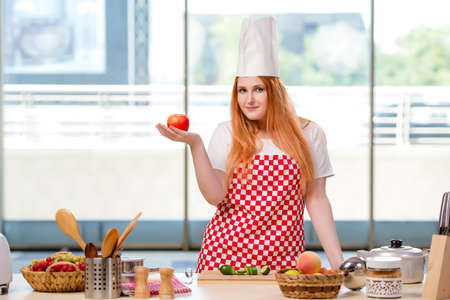 Redhead cook working in the kitchenの写真素材
