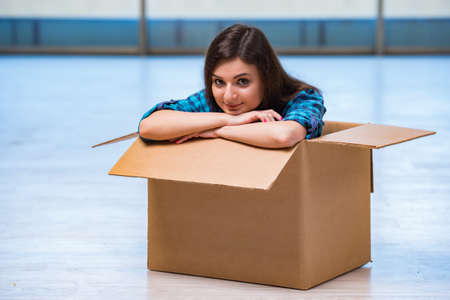 Young woman with box in moving house conceptの写真素材