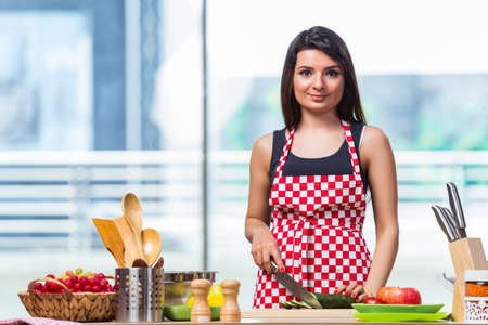 Young woman preparing salad in the kitchenの写真素材