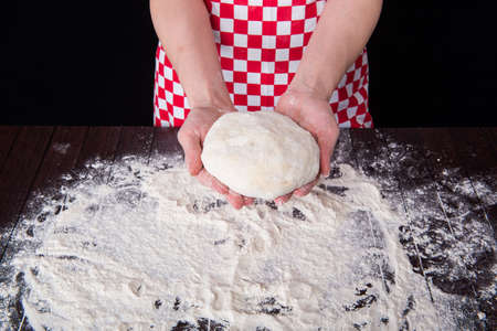 Cook preparing dough for baking in the kitchen