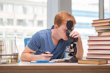 Young student tired and exhausted preparing for chemistry examの写真素材