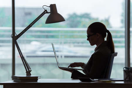 Businesswoman sitting at her desk in business conceptの写真素材