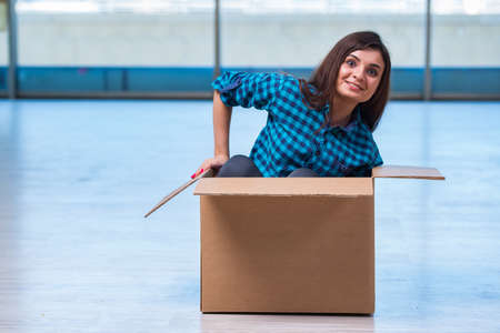 Young woman with box in moving house conceptの写真素材