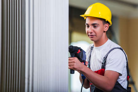 Man drilling the wall with drill perforatorの写真素材