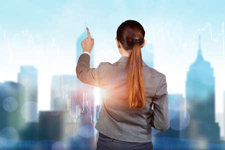 Businesswoman pressing buttons on line chartの写真素材