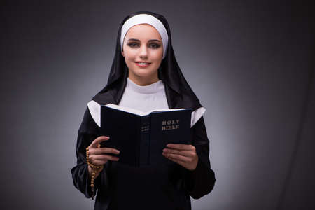 Religious nun in religion concept against dark backgroundの写真素材