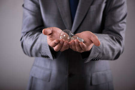 Businessman holding light bulb in creativity concept