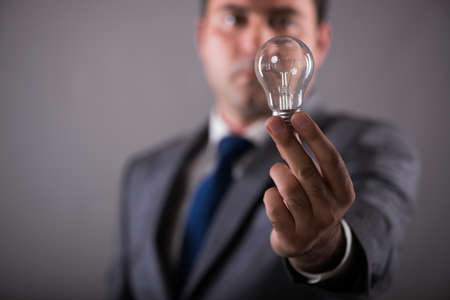 Businessman holding light bulb in creativity conceptの写真素材