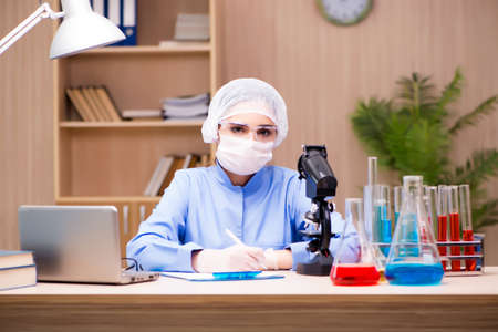 Lab chemist working with microscope and tubes