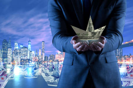 Businessman with dollar paper boats