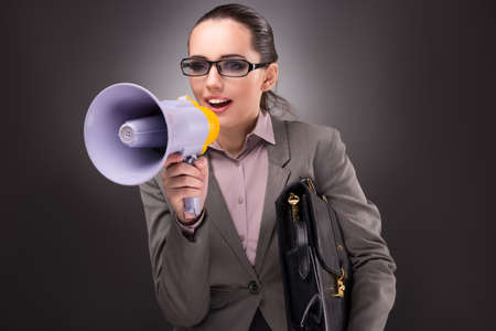 Young businesswoman with loudspeaker in business conceptの写真素材