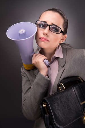 Young businesswoman with loudspeaker in business conceptの写真素材