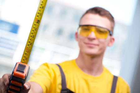 Young construction worker in yellow coverallsの写真素材