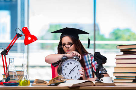Young girl preparing for exams with large clockの写真素材
