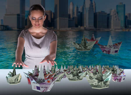 Businesswoman with dollar boats in business conceptの写真素材