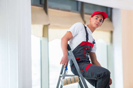 Young painter painting the ceiling in construction conceptの写真素材