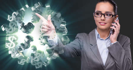 Businesswoman with dollars talking on mobile phoneの写真素材