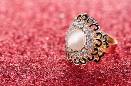 Jewellery concept with ring on shiny background